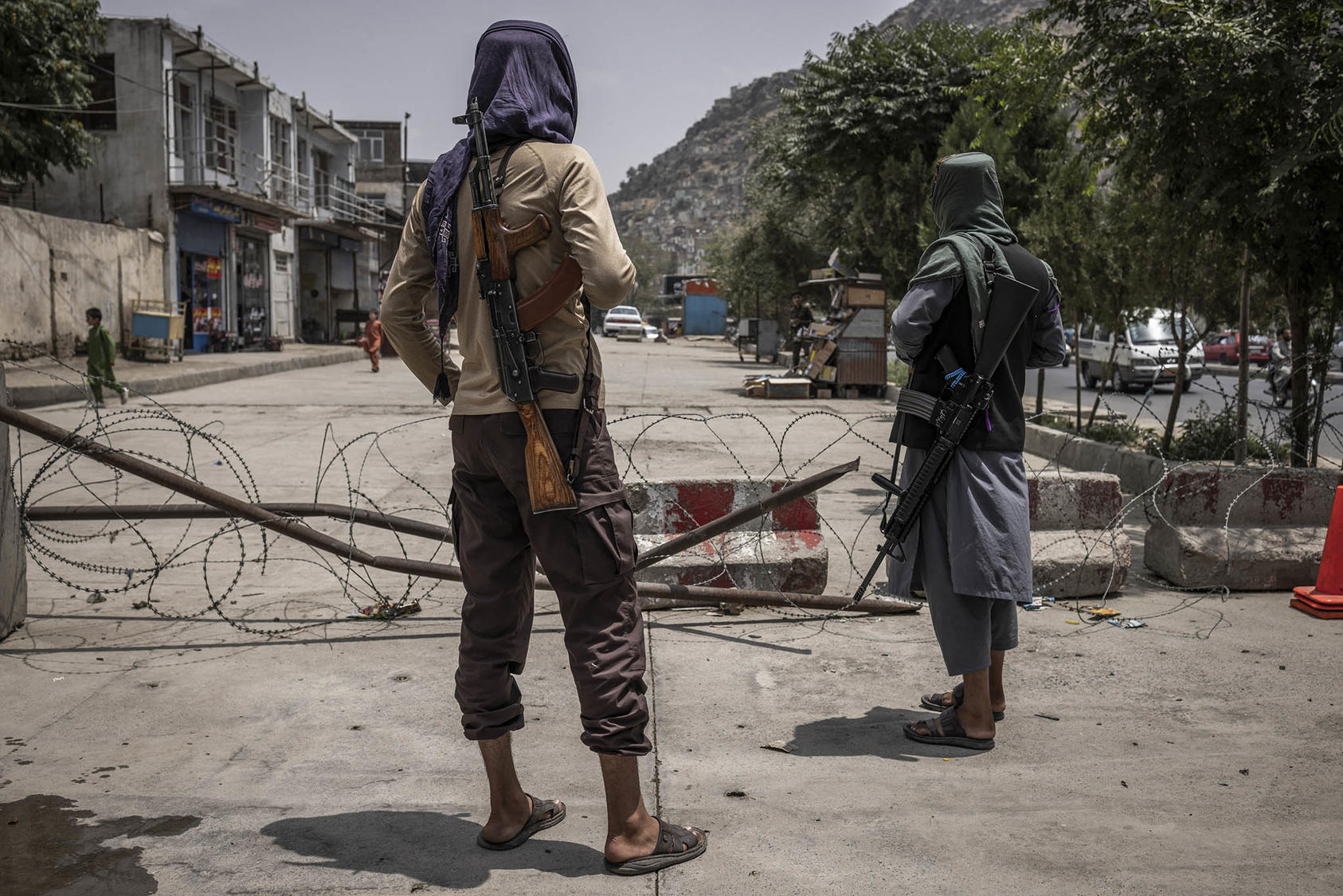 Two Taliban fighters-turned-policemen at their police post in Kabul, Afghanistan. July 23, 2023. (Jim Huylebroek/The New York Times)