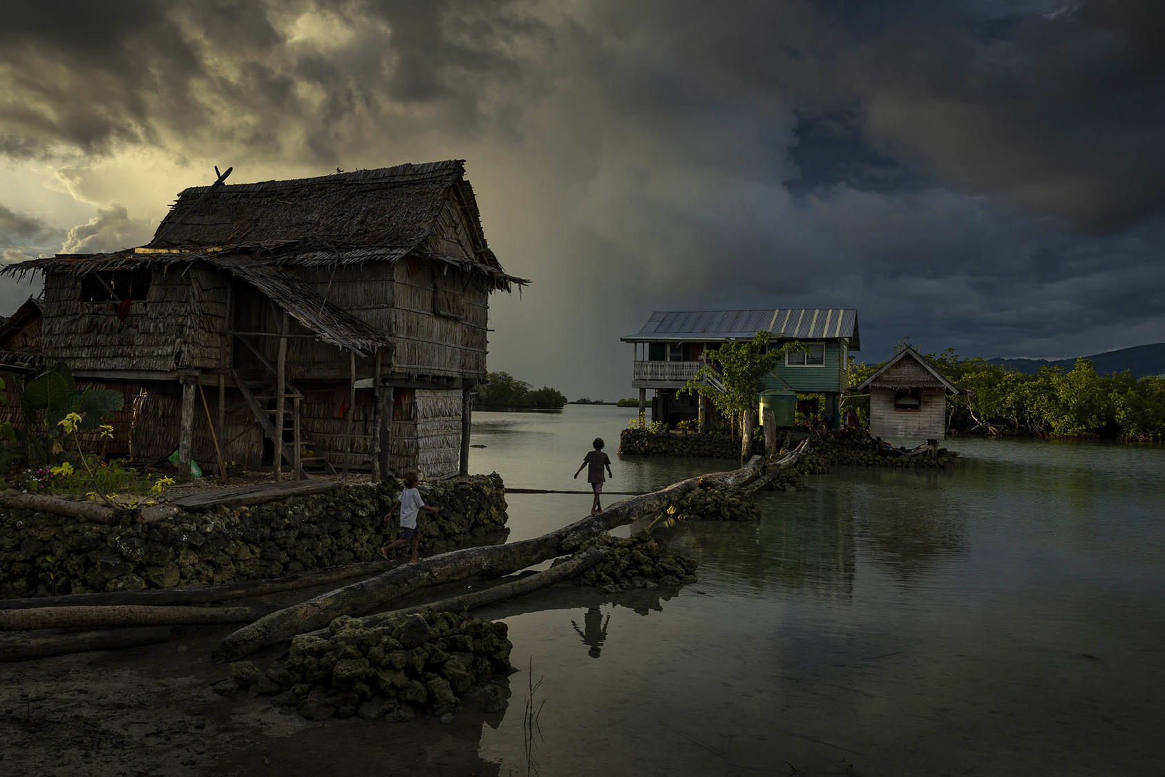 Children walk between houses at Buloabu Island, an artificial island on the Langa Lagoon, Solomon Islands, on Aug. 9, 2022. (Matthew Abbott/The New York Times).