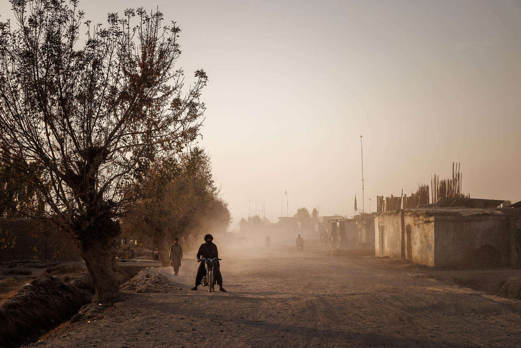 A road beside a dry irrigation canal, Marjah, Afghanistan, Nov. 8, 2021. Recurrent drought and seasonal flooding continue to threaten Afghanistan’s critical agriculture sector and limit access to clean water (Jim Huylebroek/The New York Times)