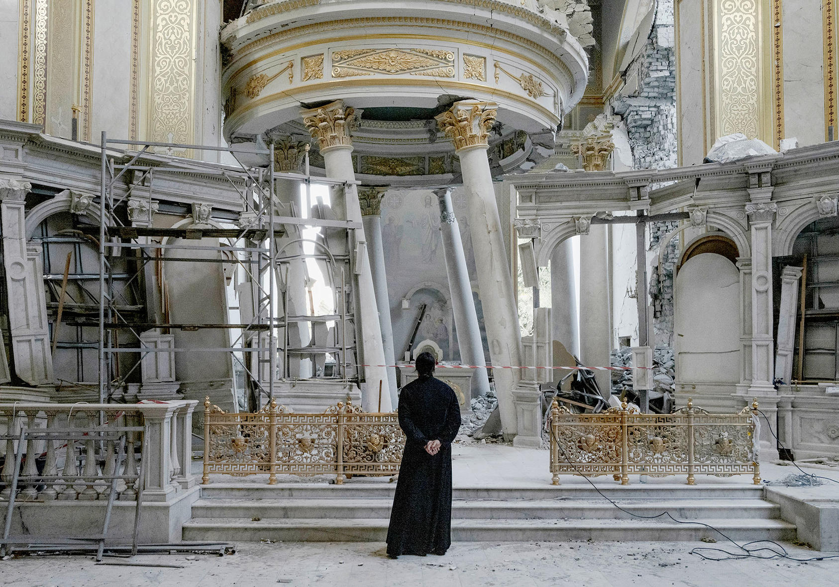 A priest inspects damage inside Transfiguration Cathedral, which was heavily damaged in Russian missile attacks, in Odesa, Ukraine, on July 24, 2023. (Photo by Emile Ducke/New York Times)
