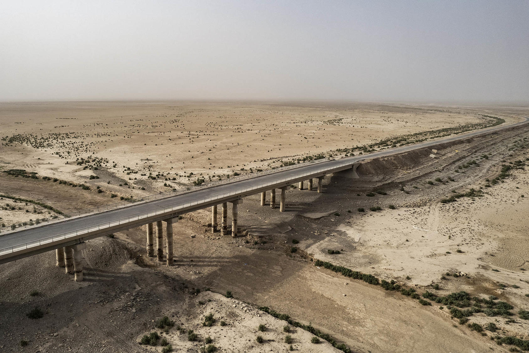 The bridge and causeway that used to run over the waters of the large man-made Lake Hamrin, northeast of Baqubah, Iraq. June 21, 2022. (Bryan Denton/The New York Times)