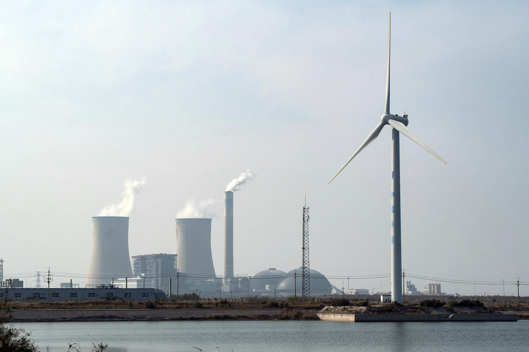 A coal-fired power plant and a wind turbine in Weifang, in Shandong Province, China. October 23, 2023. (Gilles Sabrie/The New York Times)