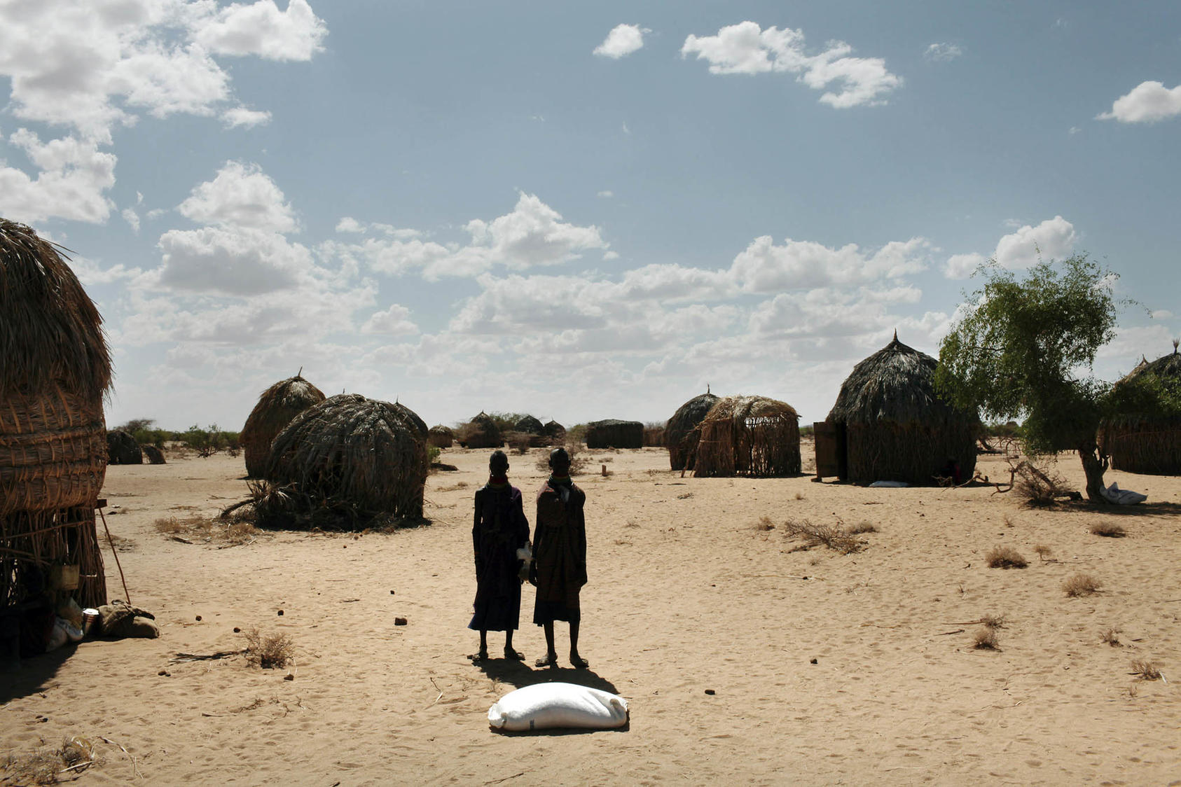 Villagers with bags of food in Lokori, Kenya, in August 2009. A devastating drought spawned an ethnic conflict in the hinterland as pastoralist communities fought over the last remaining pieces of fertile grazing land. (Jehad Nga/The New York Times)