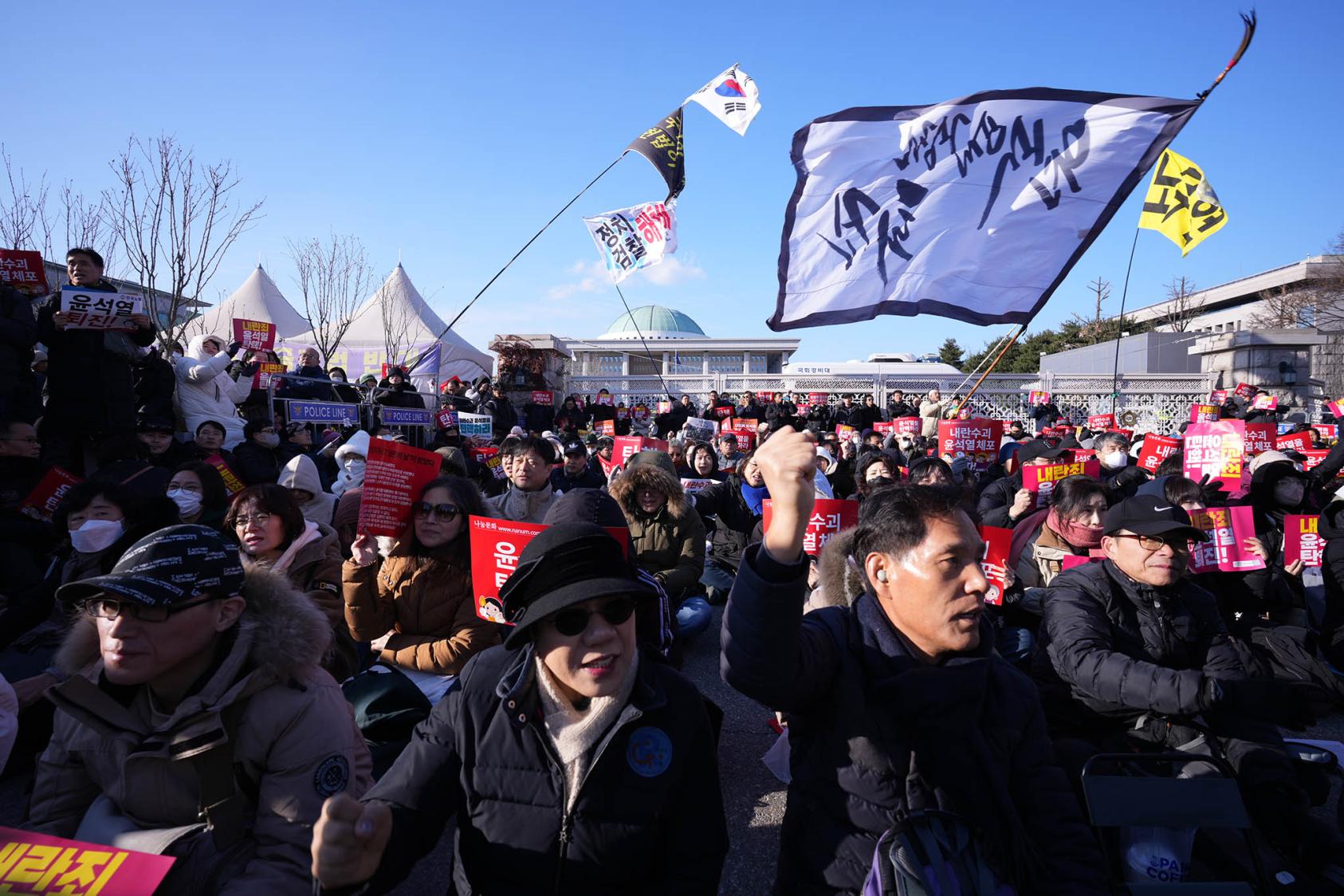 Demonstrators call for the impeachment of President Yoon Suk Yeol of South Korea, days after his brief declaration of martial law, outside the National Assembly in Seoul, on Saturday, Dec. 7, 2024. (Jun Michael Park/The New York Times)