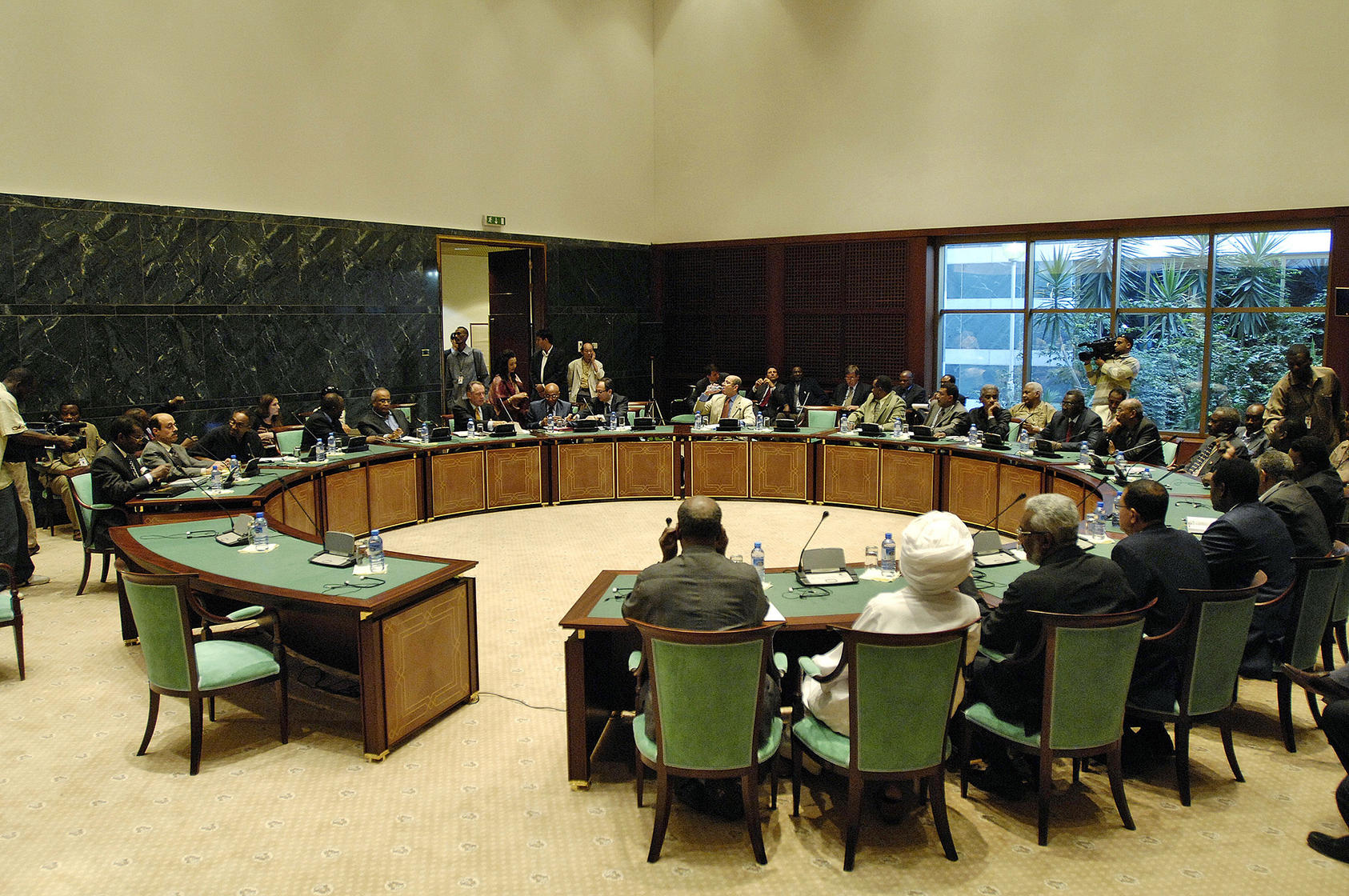 Wide-view of a closed door meeting between the African Union and the United Nations (AU/UN) mediation team (left side of table), and the delegation of the Government of Sudan (right side of table) in Sirte, Libyan Arab Jamahiriya.