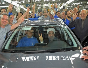 Rouhani in a car fresh off the line in a factory