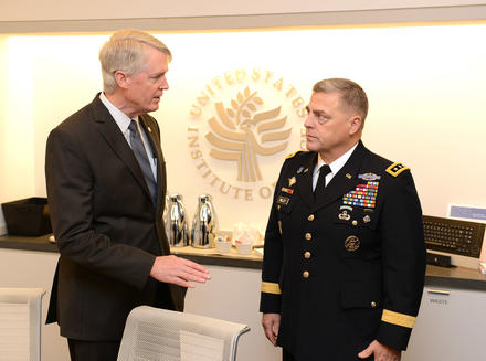 Paul Hughes talks with then-Lieutenant General Mark Milley, at a 2014 USIP conference on ways to better bring wars to their end.