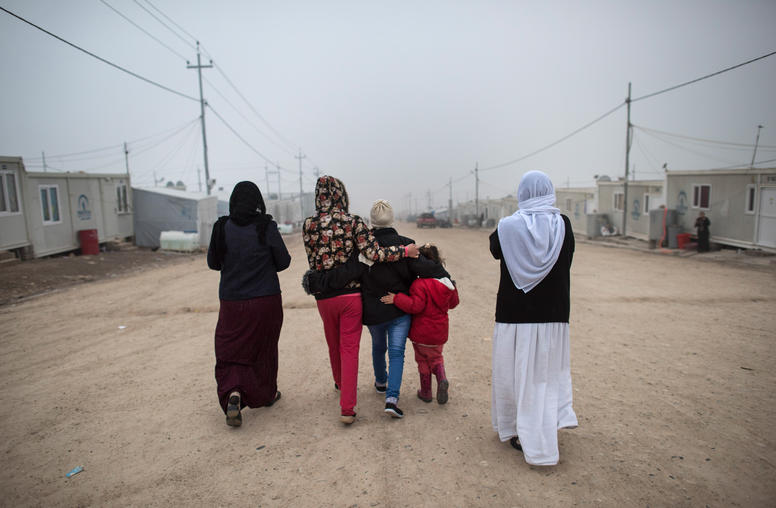 A Yazidi teen who escaped sex slavery under the Islamic State group, is comforted by relatives before leaving to be resettled in Germany, at a camp near Dohuk. Photo Courtesy of The New York Times/Lynsey Addario