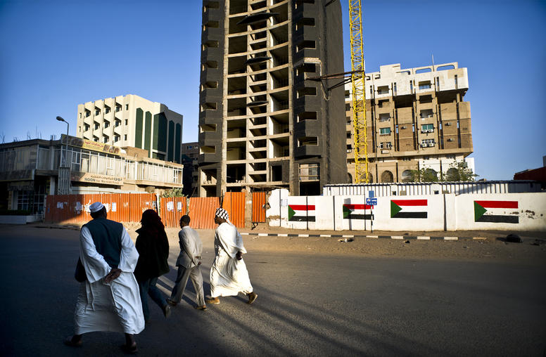 Locals walk pass a paused development project in Khartoum, Sudan, Jan. 26, 2012. (Sven Torfinn/The New York Times)