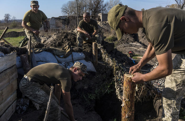 Ukrainian troops dig bunkers after withdrawing about 500 yards from the front line in the village of Stanytsia Luhanska. The pullback by both sides helped prepare for December 9 peace talks in the Russia-Ukraine war. (Brendan Hoffman/The New York Times)