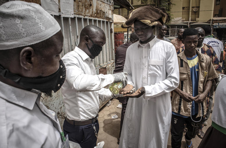 Security administers hand sanitizer ahead of Friday prayers at the Grand Mosque in Burkina Faso's capital Ouagadougou, March 13, 2020. (Finbarr O'Reilly/The New York Times)