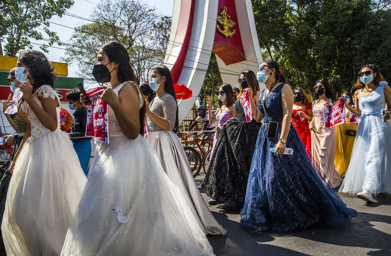 A group of women wearing formal gowns march in Yangon, Myanmar, on Feb. 10, 2021, to protest against the military coup. Despite the danger, women have been at the forefront of the protest movement. (The New York Times)