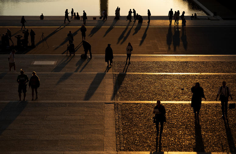 People gather to watch the sunrise at the Lincoln Memorial Reflecting Pool in Washington, Sept. 26, 2021. (Stefani Reynolds/The New York Times)