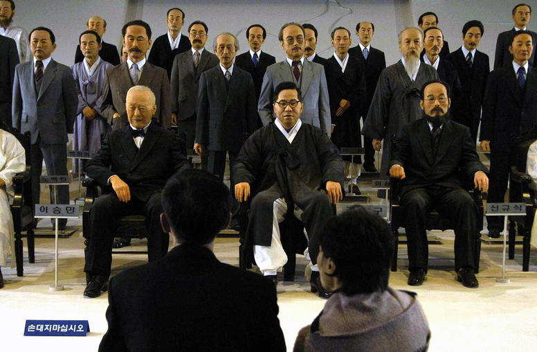 Visitors look at a display of life-size models of Koreans who resisted Japanese imperialism in Cheonan, South Korea, on Dec. 8, 2004. (Seokyong Lee/The New York Times)