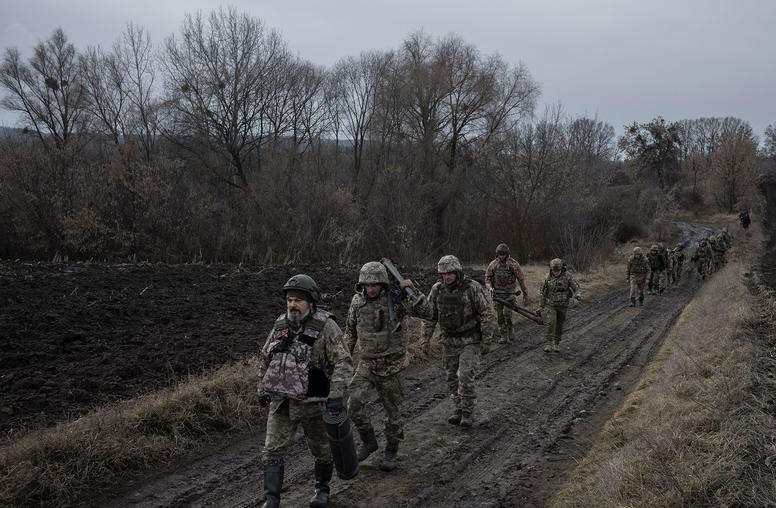 Ukrainian soldiers with the 114th Brigade of the Territorial Defense Forces carry equipment for a weapons training in the Kyiv region of Ukraine on Sunday, Feb. 26, 2023. (Emile Ducke/The New Yok Times)