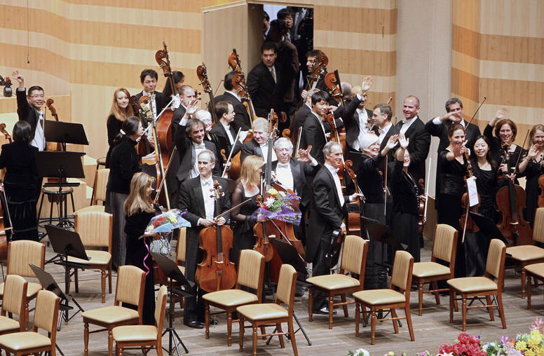 Members of the New York Philharmonic waved to the audience as they left the stage following their historic concert in Pyongyang on Feb. 26, 2008. (Chang W. Lee/The New York Times)