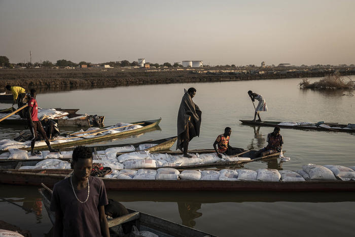 Men delivering food aid in Bentiu, South Sudan on Feb. 1, 2023. Amid an historic global hunger crisis, the U.N. World Food Programme’s chief economist calls for a “Marshall Plan for food insecurity.” (Jim Huylebroek/The New York Times)