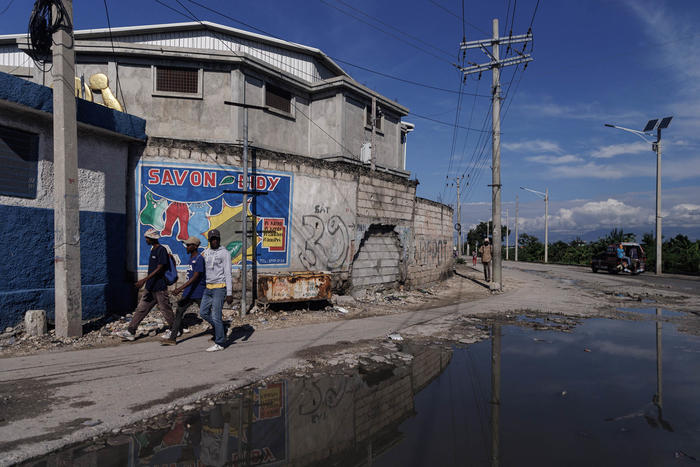 People walk by an abandoned police station in the Drouillard neighborhood of Port-au-Prince, Haiti, Nov. 7, 2022. (Adriana Zehbrauskas/The New York Times)